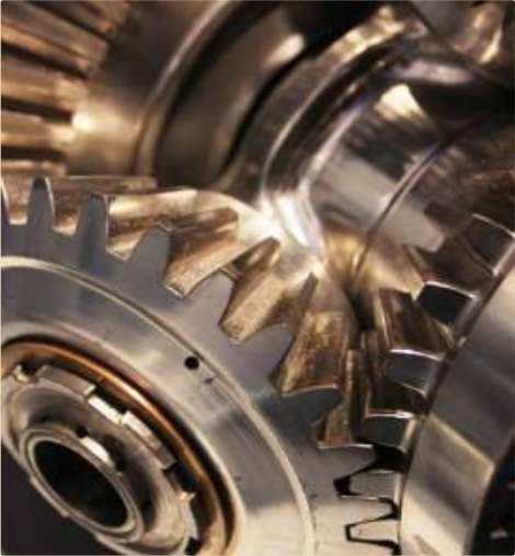 A machined gear train sealed under a self-healing waxy film.